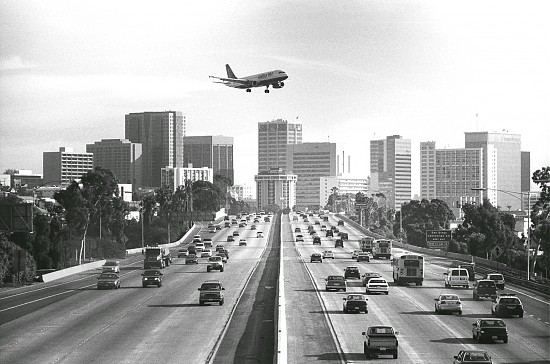 An approaching plane flies over the San Diego city skyline.