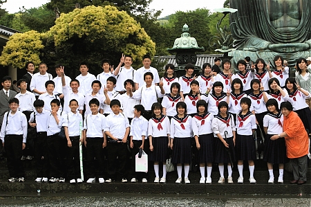 A school of Japanese school children posing for a group picture.