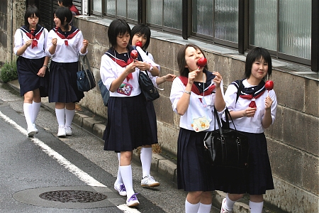 Japanese school girls in their uniforms walking home from school.