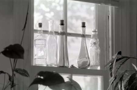 Decorative bottles on a window sill.