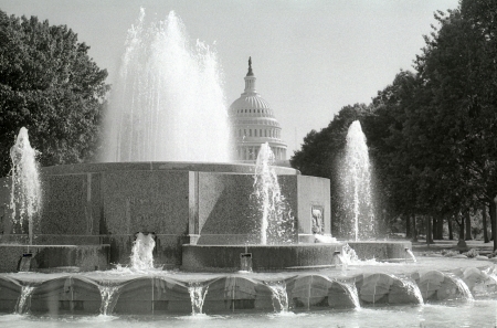 A view of a fountain and the United States Capitol dome from a park across the street.