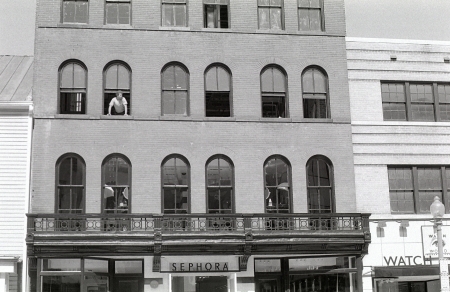 A view of a man hanging out a building window on M Street in Georgetown