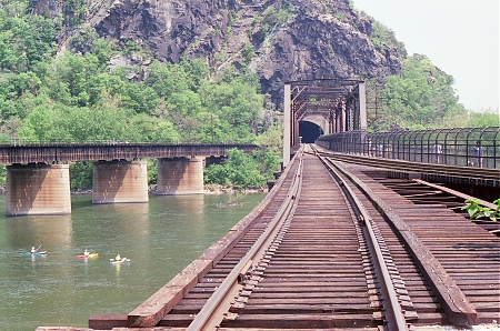 A view of the Potomac including railroad tracks heading into the Harpers Ferry National Historical Park mountain tunnel.