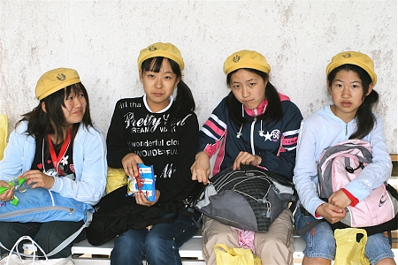 Japanese schoolgirls eating snacks at the Kamakura Daibutsa shrine in Japan.