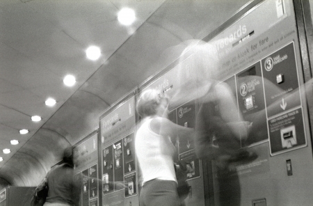 Three women rushing to purchase fare cards in the Washington DC subway.