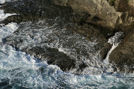 Morning waves wash over rocks along the Japanese coast.