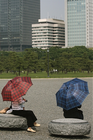 Two women relaxing with umbrellas in Japan.